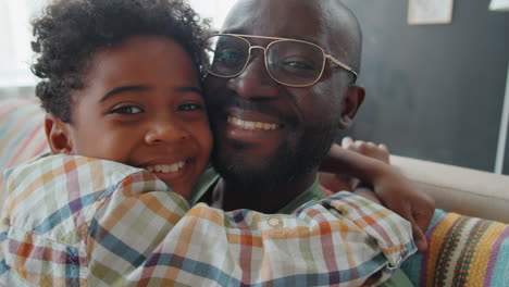 Portrait-of-Joyous-African-American-Father-and-Little-Son-Hugging-Each-Other-at-Home